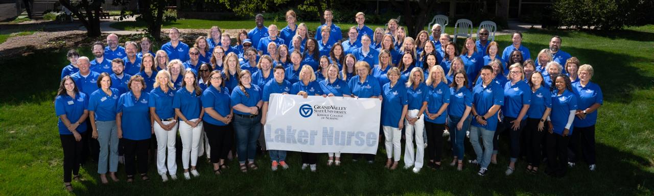 Group of people wearing blue polo shirts holding a laker nurse sign